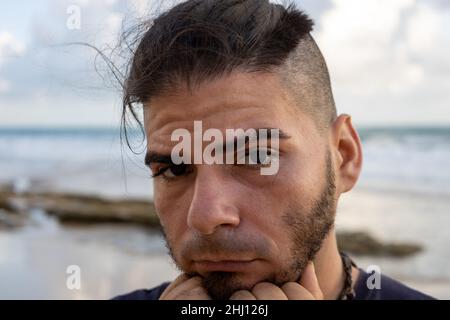 Middle-aged white man looking worried on the beach. Burn out concept. Stock Photo