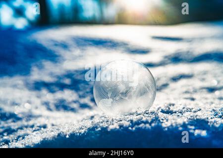 frozen soap bubble in winter on snow. magic nature Stock Photo