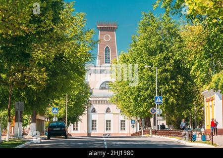 Chachersk, Belarus. People Walking On Street Near Old City Hall In Sunny Spring Day. Town Hall In Chechersk Stock Photo