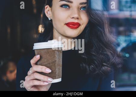 Crop young female drinking hot coffee in cafeteria Stock Photo