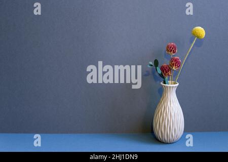 Vase of dry flowers on table. navy blue wall background. home interior decor Stock Photo