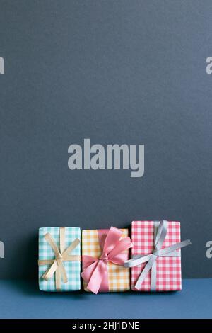 Colorful gift boxes on table. navy blue wall background Stock Photo