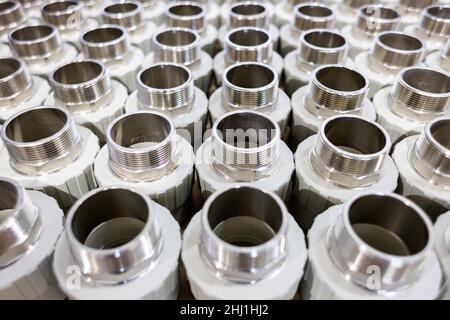 many metal pipe couplings in a pipe factory Stock Photo