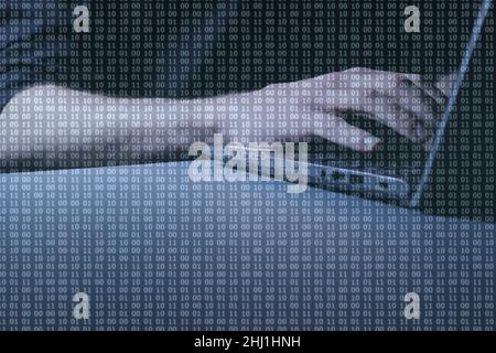 Hacked - Hands at computer with binary code overlay with the word 'HACKED' at centre of image Stock Photo