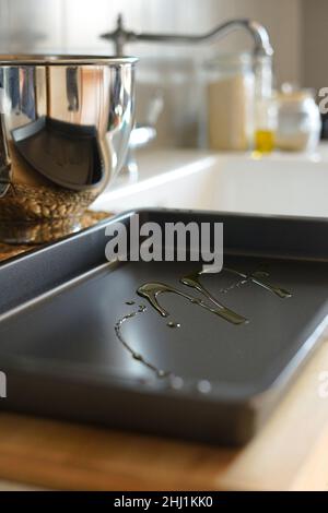 Dark new and clean baking tray with olive oil inside Stock Photo