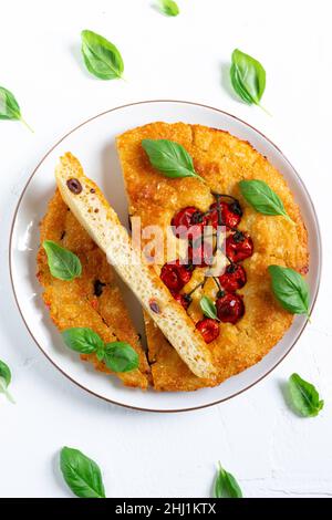 Freshly baked focaccia with cherry tomatoes on a plate Stock Photo