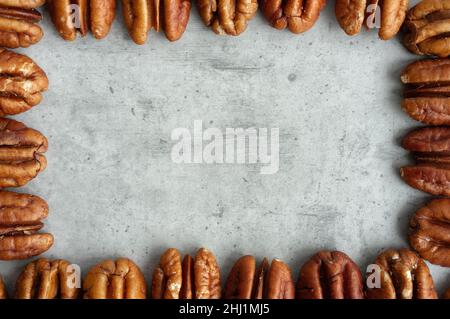 Pecan frame on gray background, top view, close-up Stock Photo