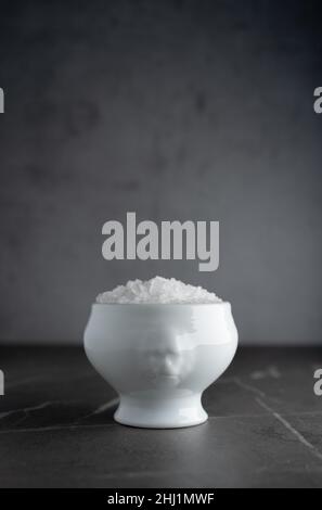 Sea salt in an unusual white ceramic bowl, with free space on top Stock Photo