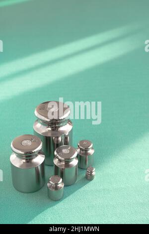 Metal chrome exact weight, turquoise background with sunlight Stock Photo