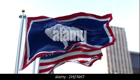 the flag of the US state of Wyoming waving in the wind with the American flag blurred in the background. Wyoming was admitted to the Union on July 10, Stock Photo