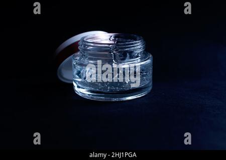 transparent jar with moisturizing cream with hyaluronic acid on a black background Stock Photo