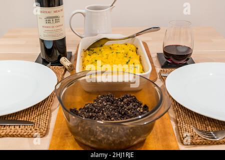 Traditional Scottish Burns Night supper meal: haggis & clapshot (mashed potato & turnip or swede) & bottle of Bordeaux claret Chateau Meaume red wine Stock Photo