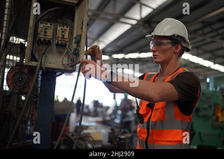 Male engineer metalworker industrial experienced operator technician worker in safety hard helmet working on lathe machine, professional man in indust Stock Photo
