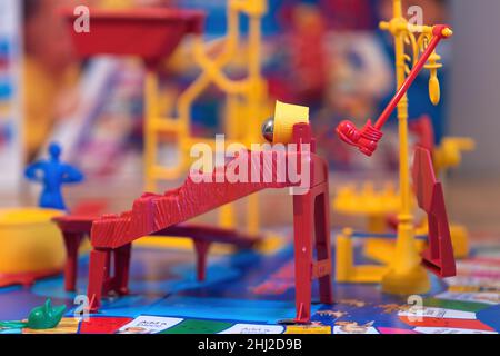 A close up view of the red boot kicking the yellow bucket over and tipping out the steel ball in the Mouse Trap board Game. Stock Photo
