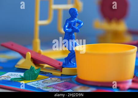 A close up shot of the blue diver standing on the See-Saw and a green mouse on the board. The diver is waiting to dive into the yellow tub. Stock Photo