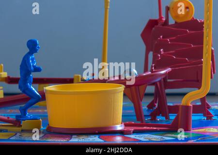 The blue diver on MouseTrap board game waits for the steel ball as it rolls down the ramp before diving into the yellow Tub that releases the cage Stock Photo
