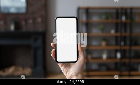 Female hand holds smartphone with white blank mockup screen, closeup Stock Photo
