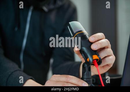 Closeup hand of young man podcast creator or radio host taking microphone Stock Photo