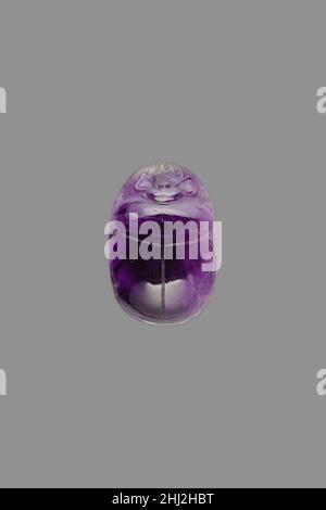 Scarab ca. 1981–1950 B.C. Middle Kingdom This scarab was made out of amethyst, a semi-precious stone. Polished to a striking degree, the piece has a beautiful reflective surface that might have alluded to the sunlight. The amulet’s flat underside is undecorated, which is often the case for scarabs in semi-precious stones. Possibly the shape and material of such scarabs might have been regarded as providing enough magical power without added text or images, though an additional inscribed gold plate might have originally covered the scarab’s base.The scarab beetle’s habit of rolling large dung b Stock Photo