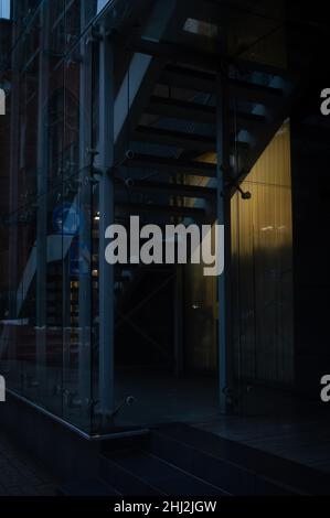 Dark theme city scape with dark entrance, stairs and burning lamp in the darkness Stock Photo