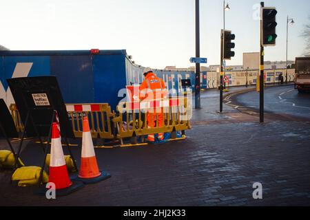 A hole in the road for HS2 groundworks with workmen in action Stock Photo