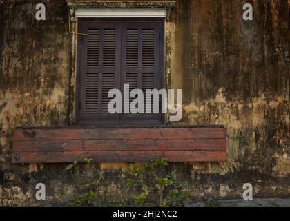 Old brown wall with window shutters in ancient city Hoi An, Vietnam Stock Photo
