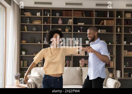 Happy African couple dancing in living room Stock Photo