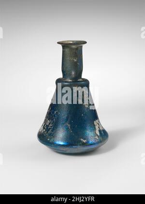 Glass perfume bottle 1st century A.D. Roman Translucent blue.Thin, everted rim; cylindrical neck, with tooled indent around base; narrow, horizontal shoulder, with rounded edge and vertical band below; carinated body, with side to long, upper body tapering downward and lower side curving in sharply; almost flat bottom, with slight, off-center indent.Intact; some bubbles; dulling, pitting, and iridescent whitish weathering, with soil encrustation on interior of neck.. Glass perfume bottle  245417 Stock Photo