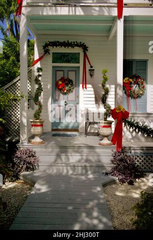 Front door with Christmas decorations in Key West, Florida, FL, USA.  Conch home with red bows Stock Photo