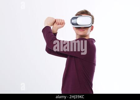 Young man using a VR headset and playing in virtual reality isolated on white background. Copy space and mock up Stock Photo