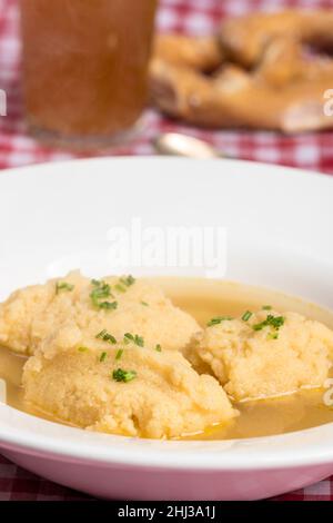 bavarian dumpling soup on tablecloth Stock Photo