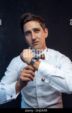Handsome businessman in white shirt against gray background. Stock Photo