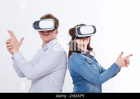 Young man and woman in casual clothes in virtual goggles, vr isolated on white background. Technology and innovation concept. Copy space and mock up. Stock Photo