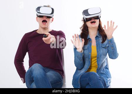 Young man and woman in casual clothes in virtual goggles, vr isolated on white background. Technology and innovation concept. Copy space and mock up. Stock Photo