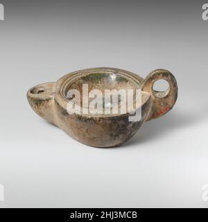 Terracotta oil lamp 1st century A.D. Roman Lead-glazed lamp with handle.. Terracotta oil lamp. Roman. 1st century A.D.. Terracotta; lead-glazed ware. Early Imperial. Terracottas Stock Photo