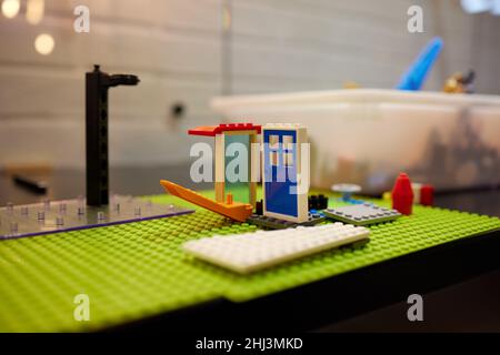 A colorful constructor set, which lies on the floor of a house, close-up. Educational games for children. plastic children's designer cubes, selective Stock Photo