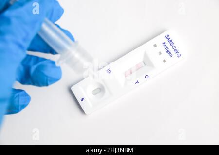 Man makes a covid-19 antigen pcr test macro. The test showed a positive result Stock Photo