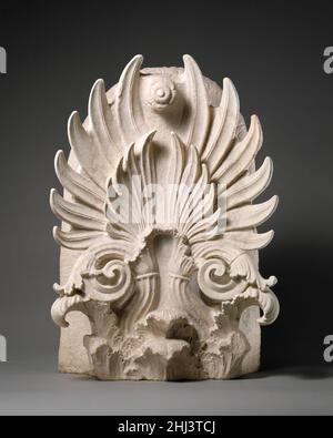 Marble akroterion ca. 350–325 B.C. Greek, Attic Restored: ends of all but one palmette leaf, parts of the volutesBoth faces of the akroterion are carved. The front is decorated in relief with a double palmette, its stems rising in the form of spiral tendrils from a bed of acanthus leaves; the flower at the top once had a painted stem. A similar decoration on the back was left unfinished.. Marble akroterion  250951 Stock Photo
