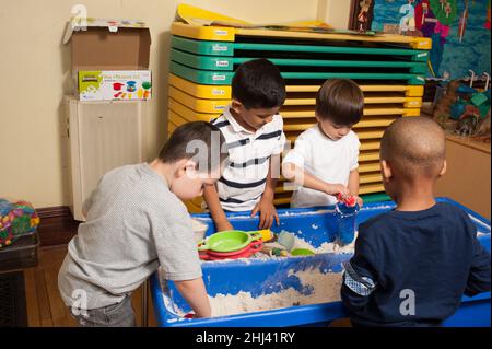 Education Preschool group of boys playing at sand table Stock Photo