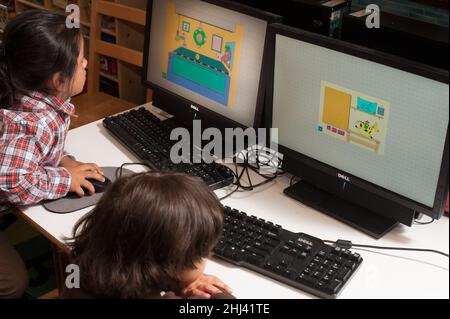 Education Preschool 3-4 year olds two children sitting side by side playing educational games on computers Stock Photo