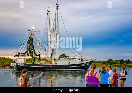 Family members watch as Apalachee Girl, a shrimp boat, arrives home after a long shrimping trip, Oct. 27, 2013, in Bayou La Batre, Alabama.