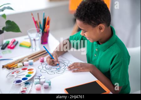 Boy drawing with color pencil sitting at table Stock Photo