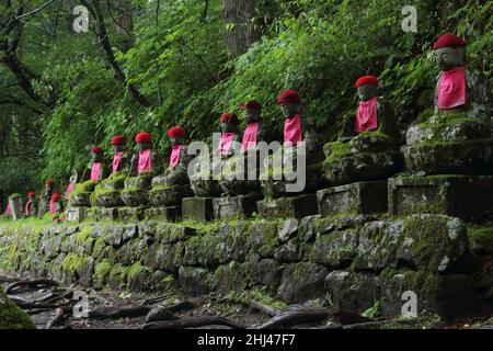 Impresive japanese landmark - aligned buddhist jizo statues in Nikko, Japan. Photo is taked at long exposure in the dusk. Stock Photo