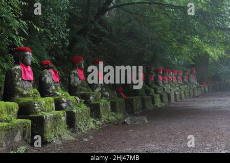 Impresive japanese landmark - aligned buddhist jizo statues in Nikko, Japan. Photo is taked at long exposure in the dusk. Stock Photo