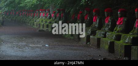 Impresive japanese landmark - aligned buddhist jizo statues in Nikko, Japan. Photo is taked at long exposure in the dusk. Stock Photo