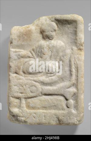 Fragment of a marble votive relief dedicated to a hero 4th–3rd century B.C. Greek Relief fragment with funerary banquet.. Fragment of a marble votive relief dedicated to a hero  255696 Stock Photo