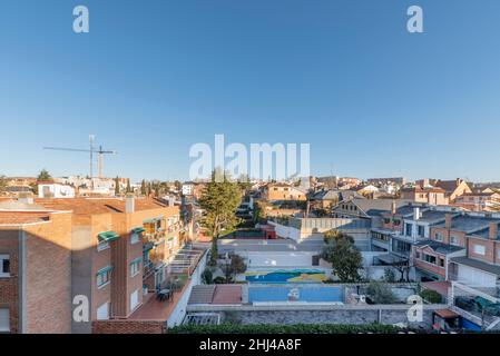 Views of residential single family home rooftops with pools and trees in the early morning Stock Photo