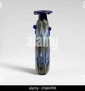 Glass alabastron (perfume bottle) late 4th–early 3rd century B.C. Eastern Mediterranean or Italian Translucent cobalt blue, with handles in same color; trails in opaque yellow, opaque white, and opaque turquoise blue.Broad horizontal rim-disk; cylindrical neck, tapering upward; narrow, almost horizontal shoulder; straight-sided cylindrical body, with slight upward taper; convex bottom, with off-center tooling indent and applied small blob of blue glass; below shoulder, two vertical ring handles, unpierced, with trailing tails, one of which is higher up body than the other, applied over trail p Stock Photo