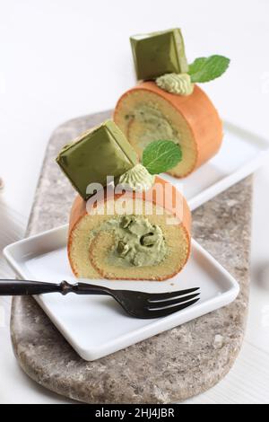 Japanese Green Tea Matcha Roll Cake with Chocolate Greentea Topping, Sliced Stock Photo