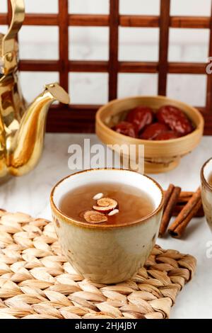 Sujeonggwa, Korean Traditional Cinnamon Punch. Dark Reddish Brown in Color, it is Made from Cinnamon Stick, Gotgam, and Ginger and is Garnished with P Stock Photo